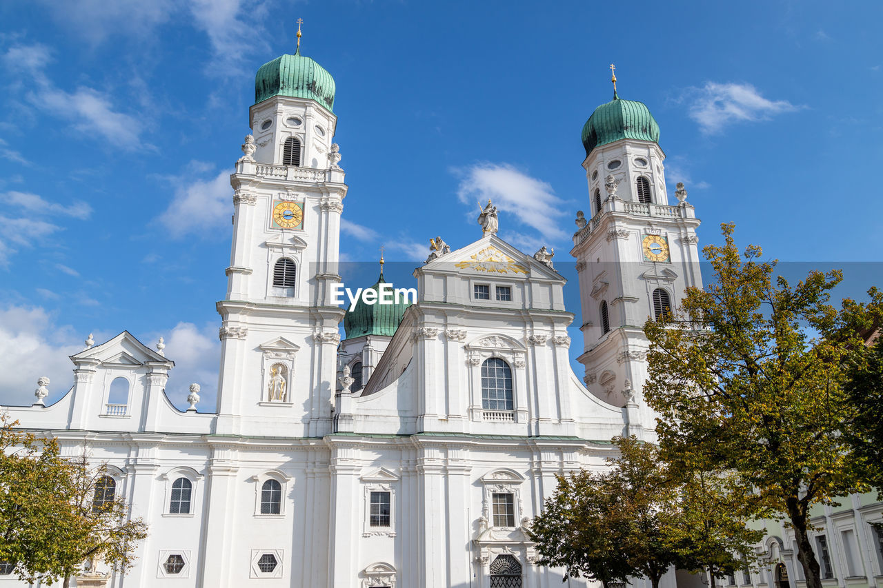 The front of st. stephen's cathedral in passau, bavaria, germany in autumn with multicolored trees 
