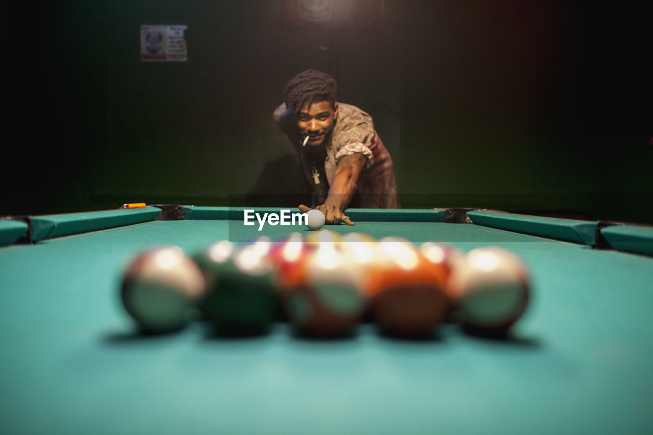 A young man playing pool. 