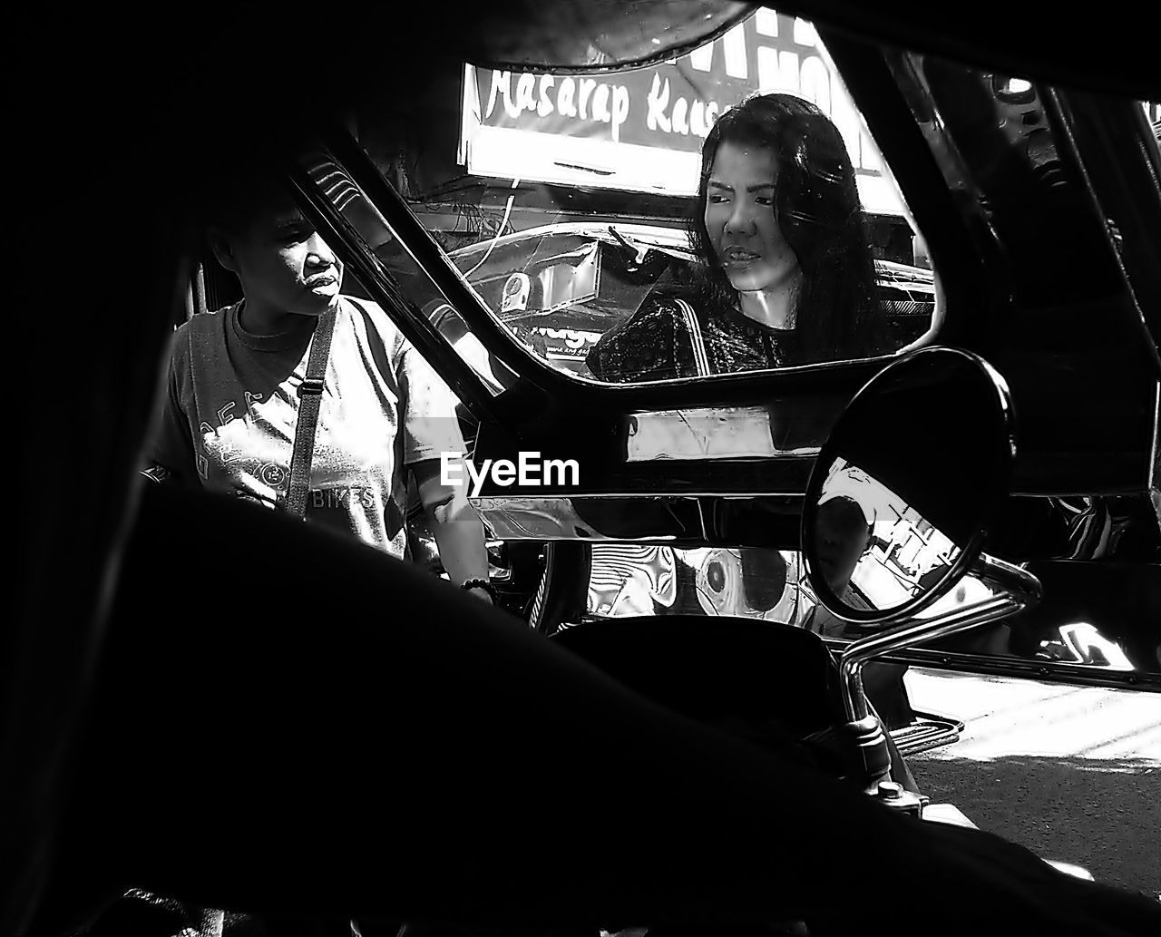 black, black and white, monochrome, monochrome photography, mode of transportation, adult, men, sitting, transportation, indoors, one person, communication, car, motor vehicle, darkness, lifestyles, land vehicle