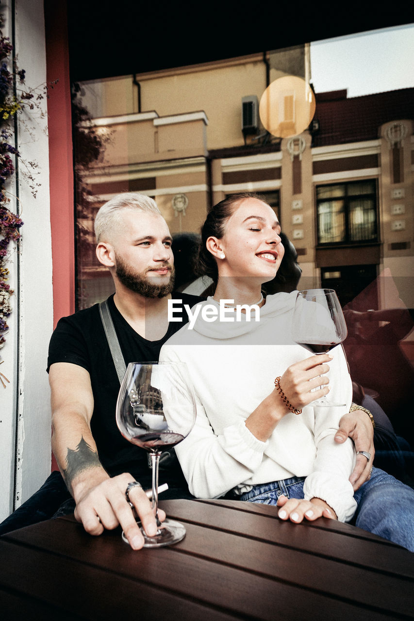 YOUNG MAN AND WOMAN SITTING AT TABLE