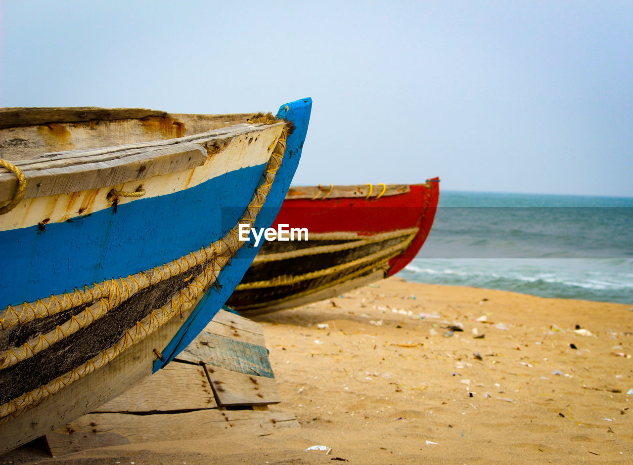 Boats on beach against clear sky