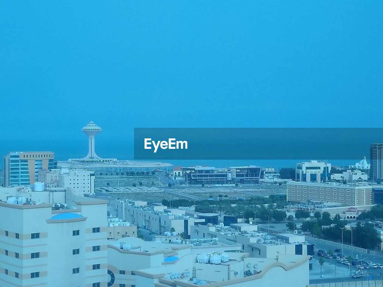 HIGH ANGLE VIEW OF BUILDINGS IN CITY AGAINST BLUE SKY