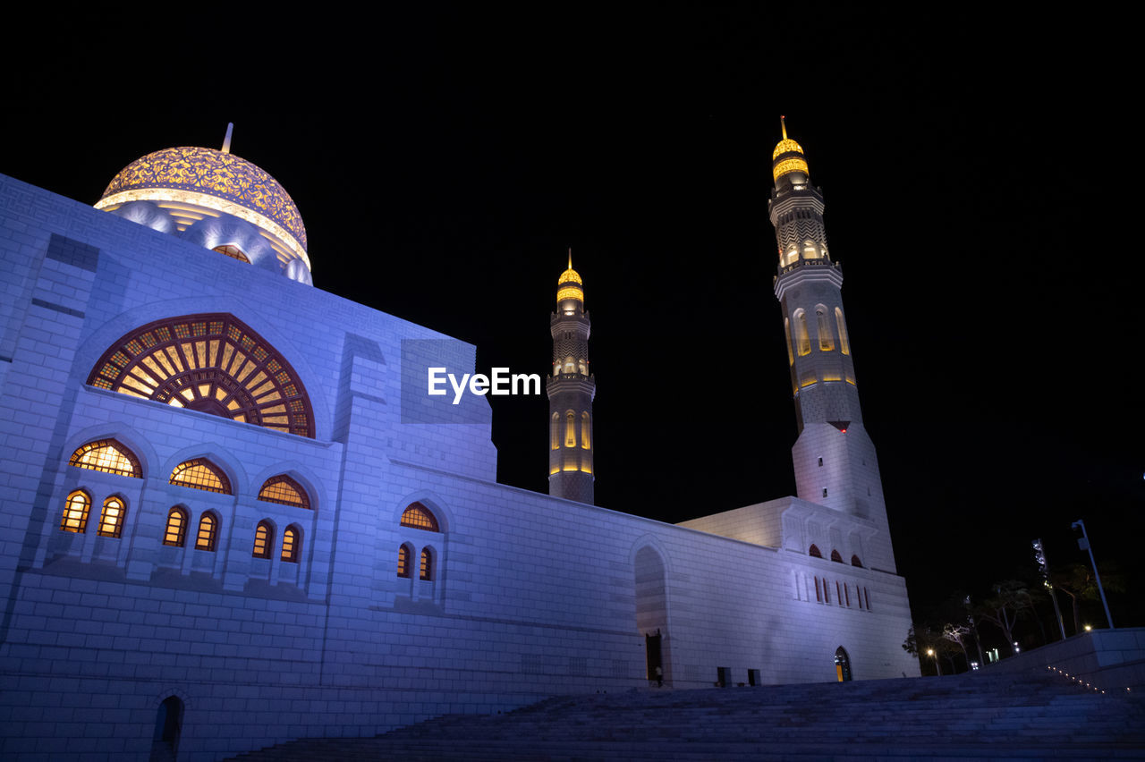 Low angle view of illuminated building against sky at night