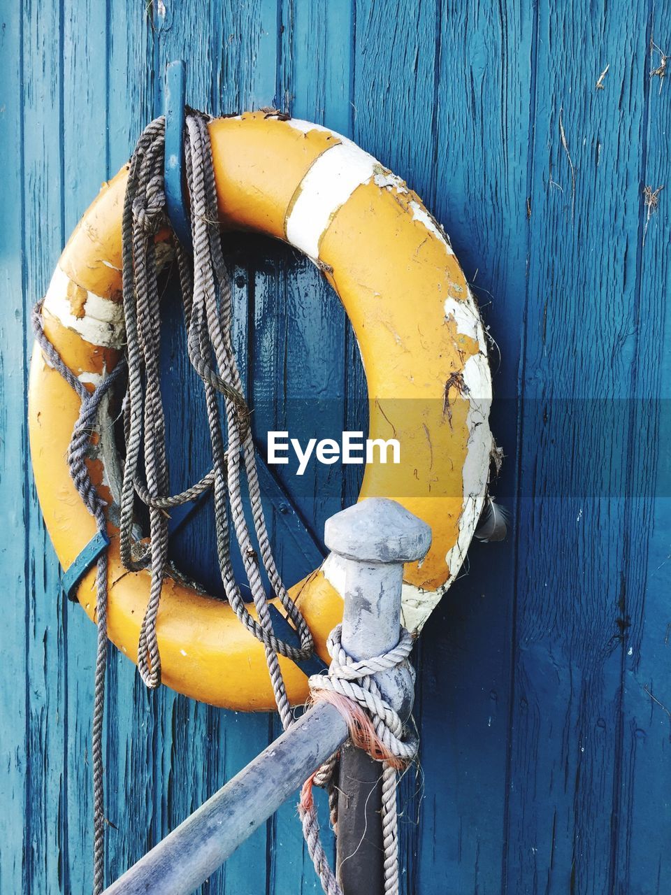 Close-up of life belt hanging on wooden wall