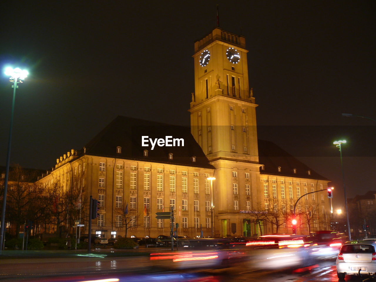 ILLUMINATED CLOCK TOWER IN CITY AT NIGHT