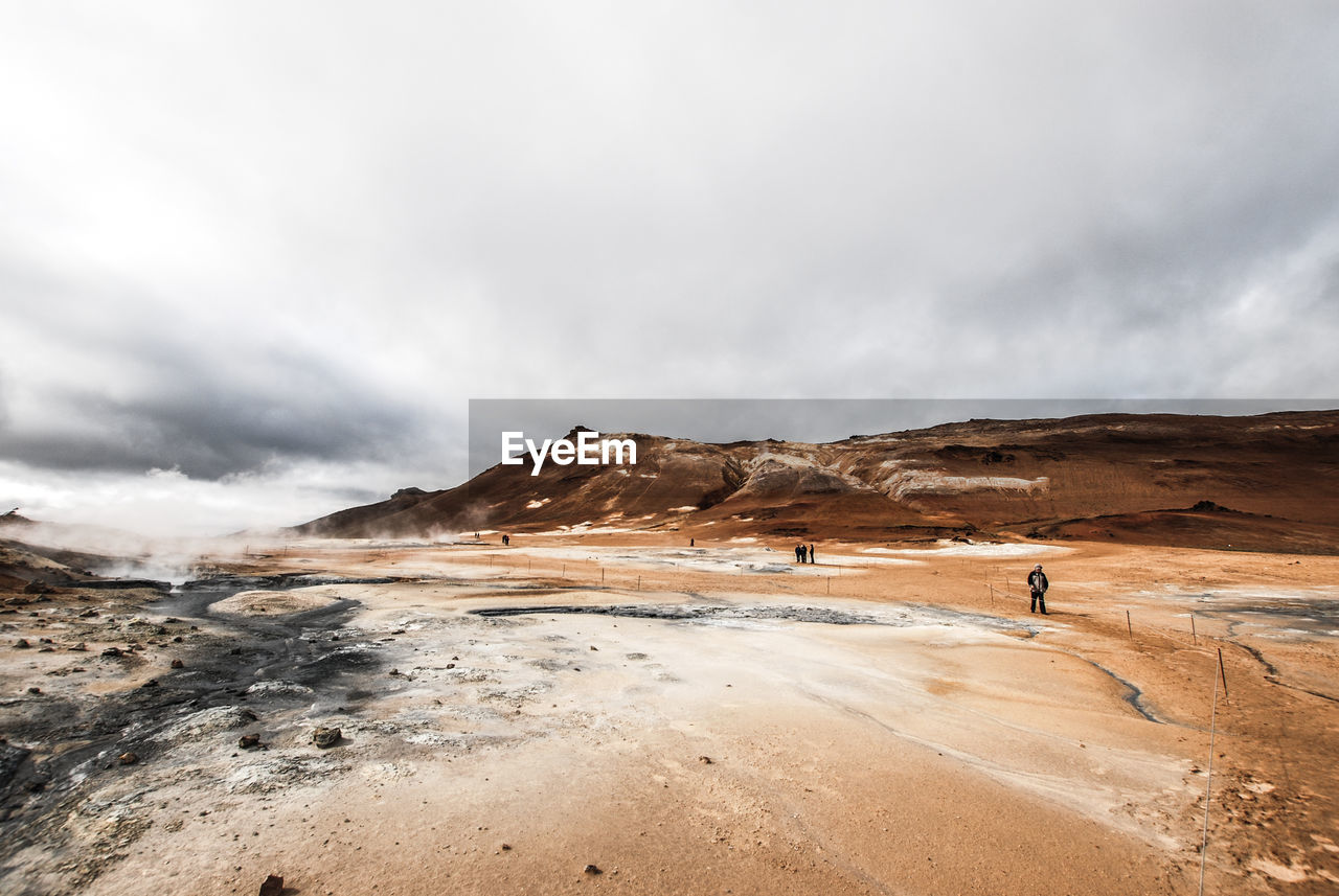 MAN STANDING ON MOUNTAIN