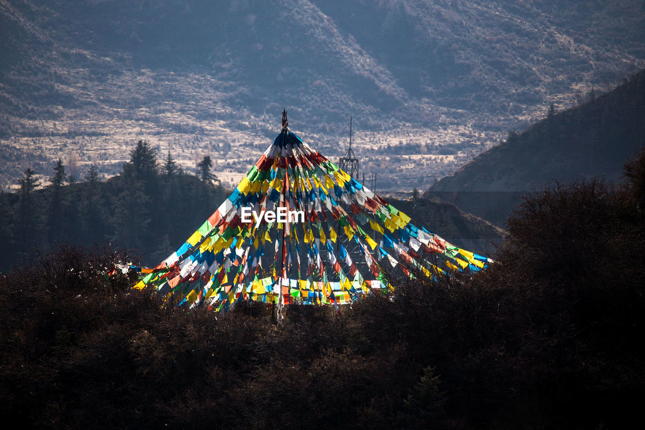 HIGH ANGLE VIEW OF ILLUMINATED LIGHTING EQUIPMENT HANGING ON MOUNTAIN