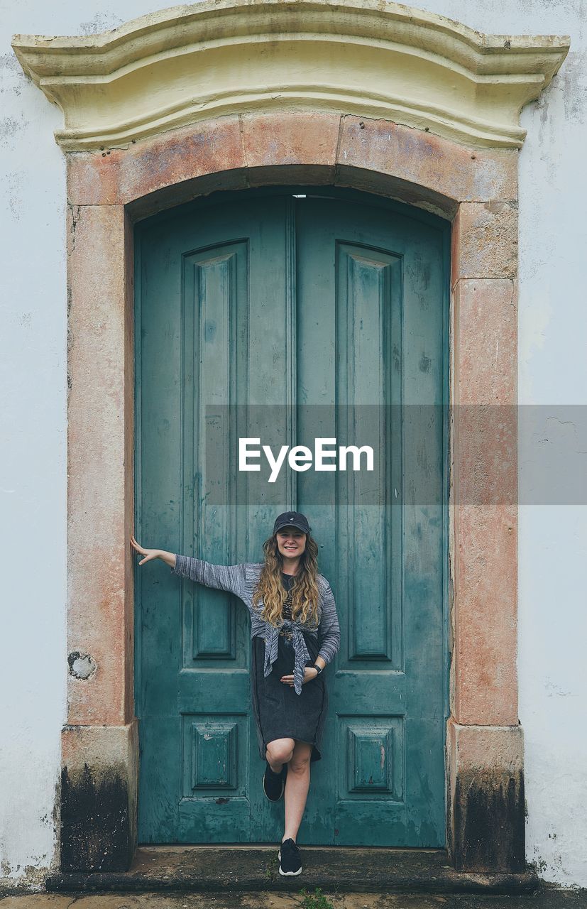 Portrait of woman standing against closed door