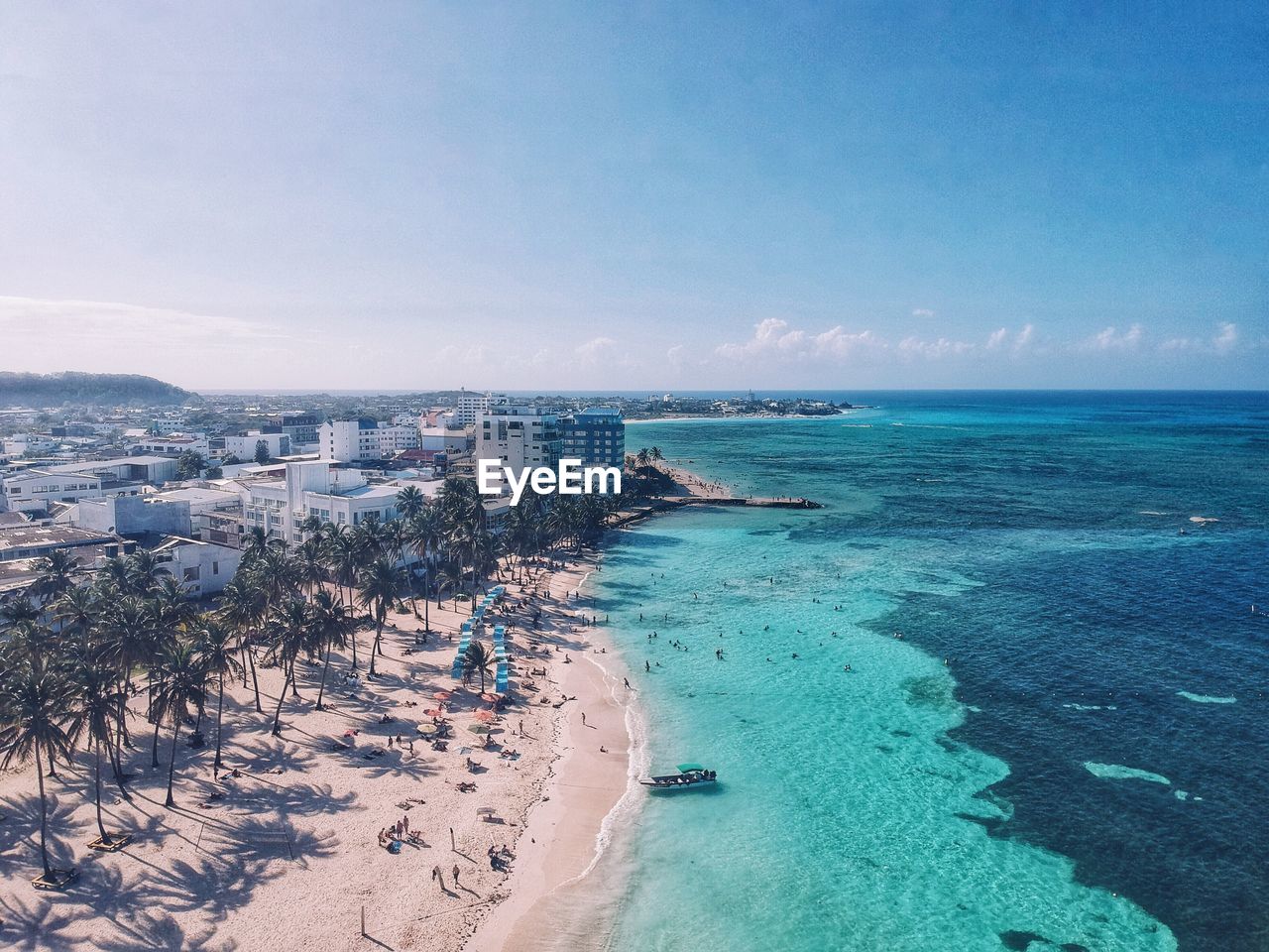 Aerial view of seascape against blue sky during sunny day