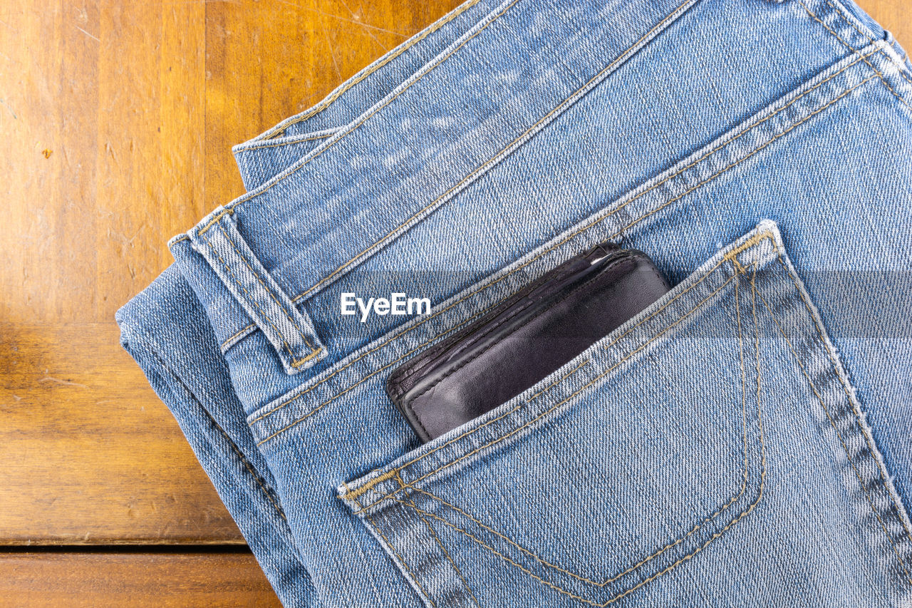 Directly above shot of wallet in jeans on table