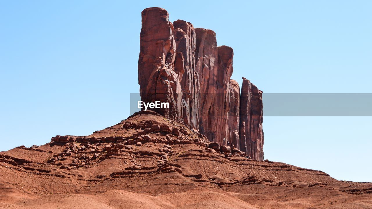 Low angle view of rock formation in desert against clear sky