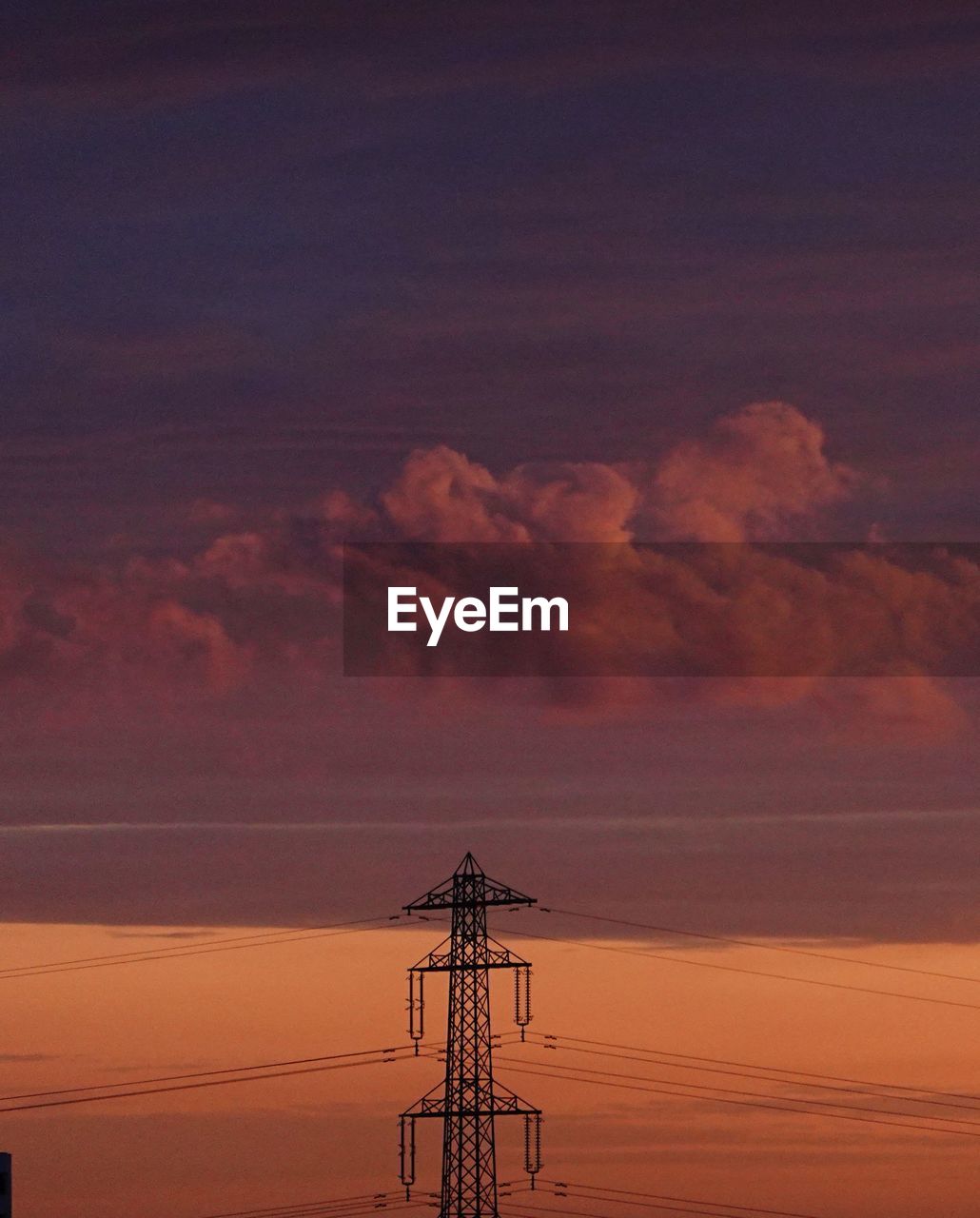 Low angle view of silhouette electricity pylon against sky during sunset