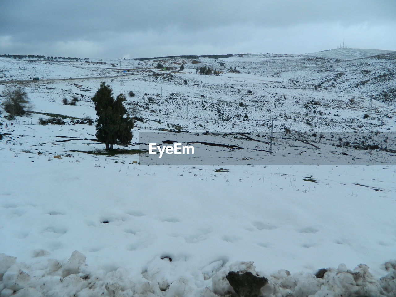 VIEW OF SNOW COVERED LAND AGAINST SKY