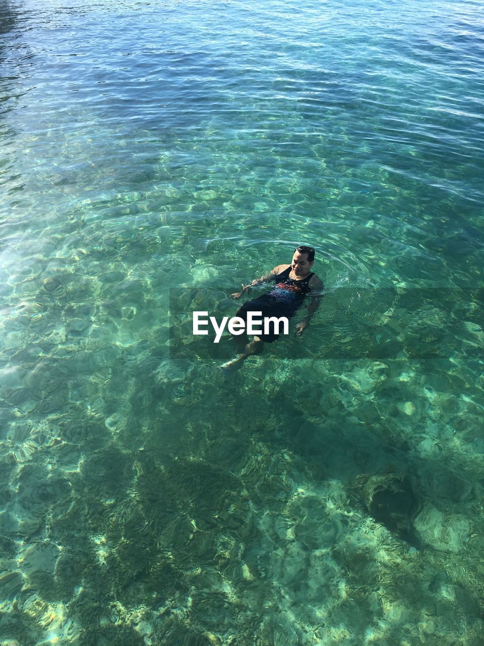 High angle view of mid adult man swimming in sea