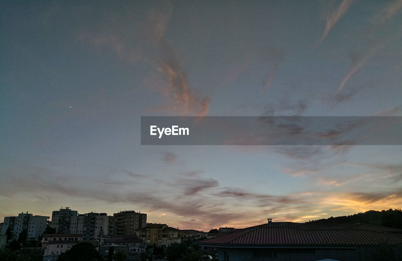 Silhouette cityscape against sky during sunset