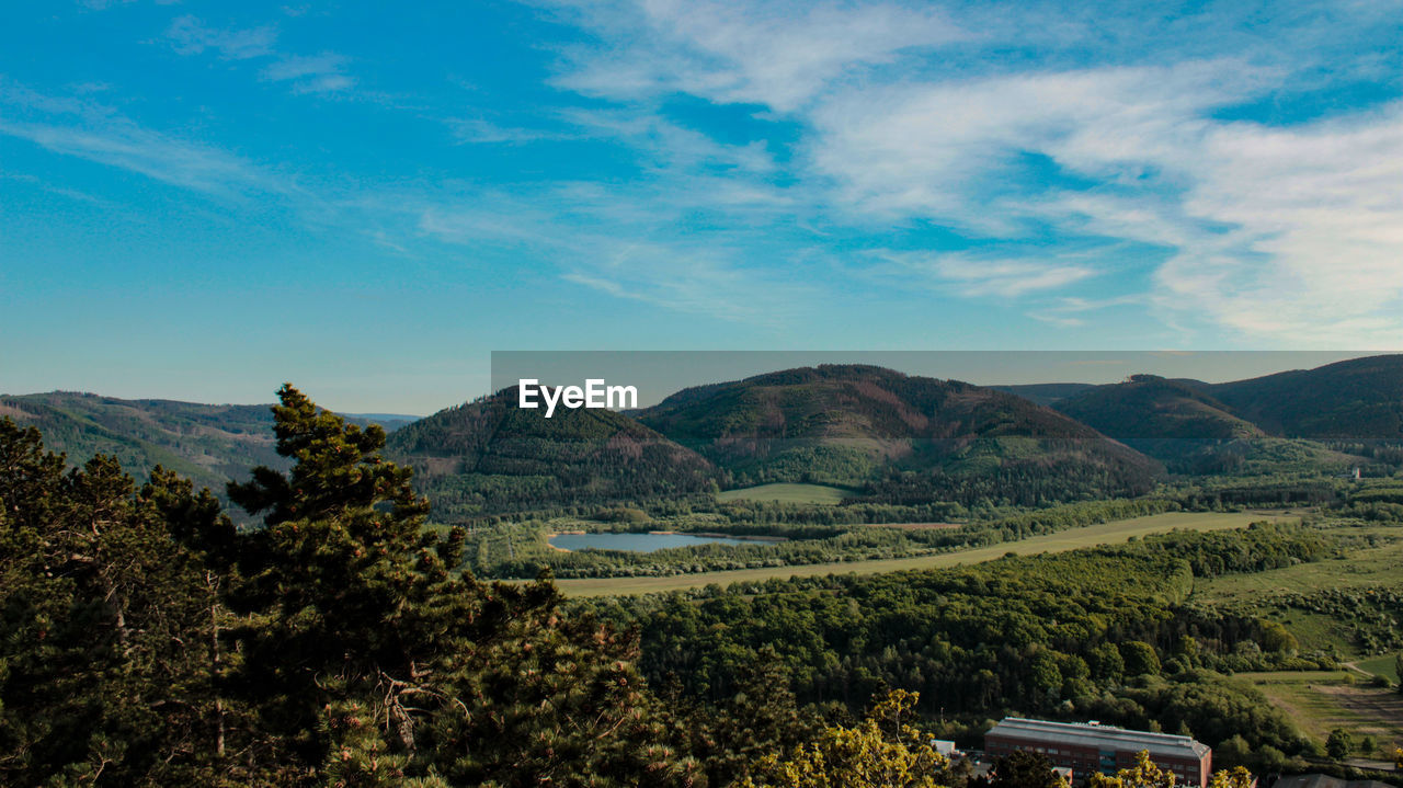SCENIC VIEW OF TREES AND MOUNTAINS AGAINST SKY