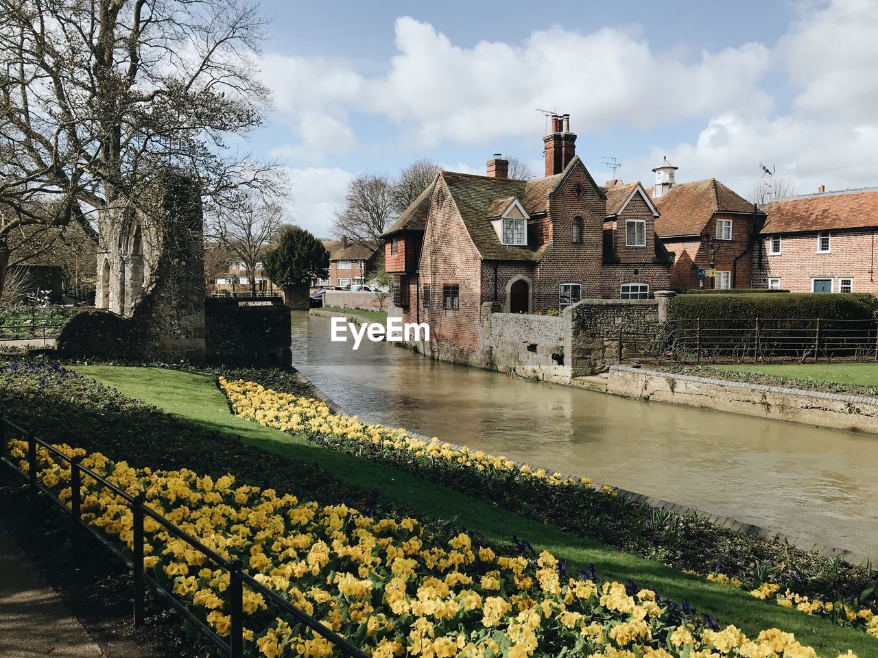 Scenic view of river by buildings against sky