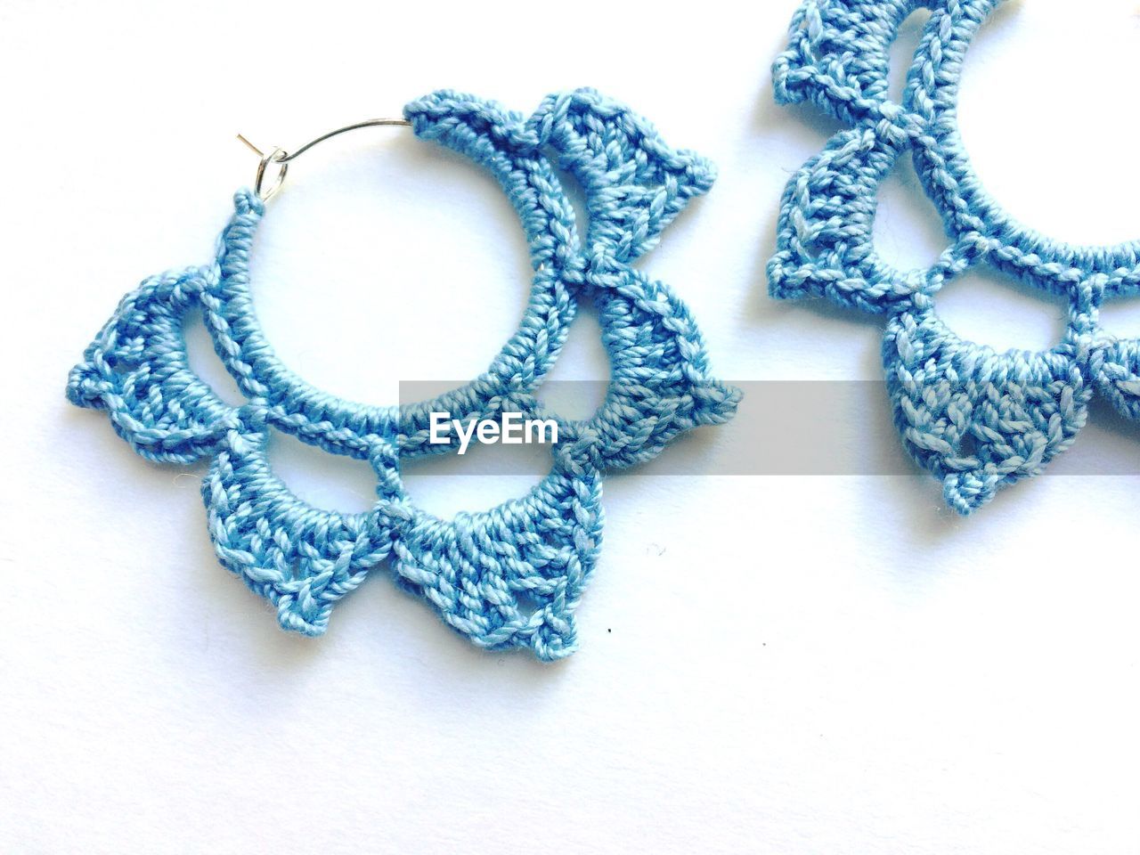 Close-up of crochet earrings on white background