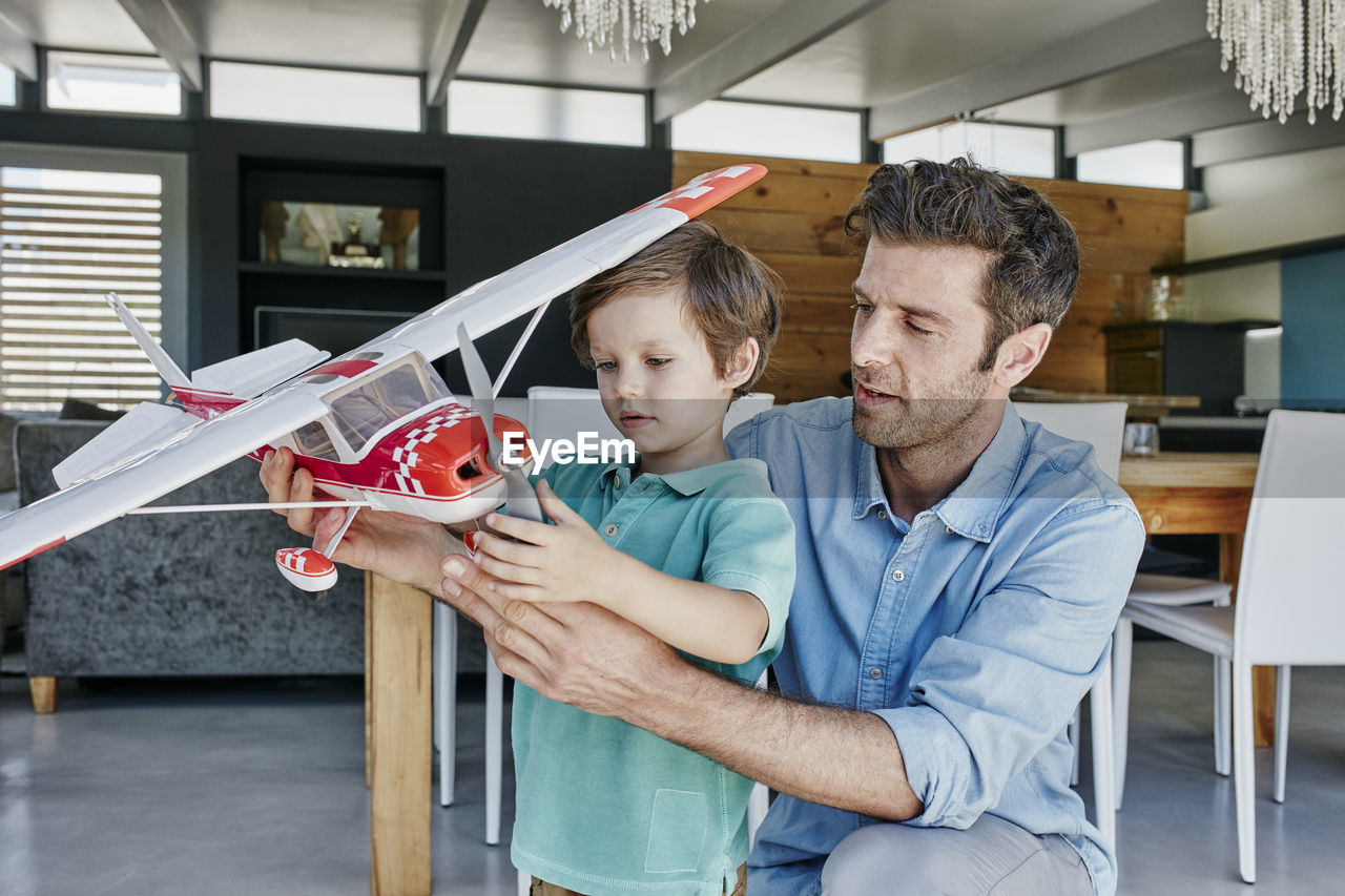 Father and son playing with toy airplane