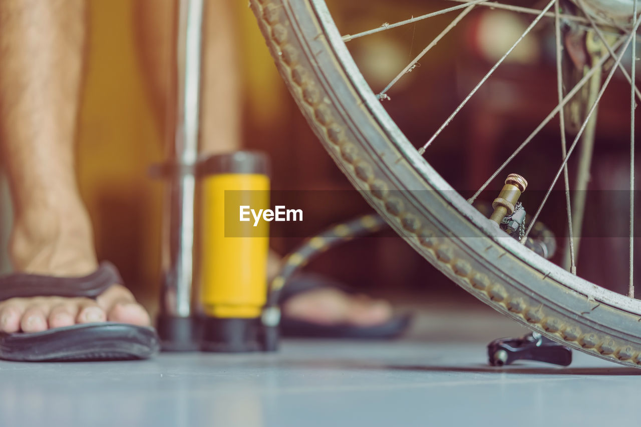 Close-up of man pumping bicycle wheel
