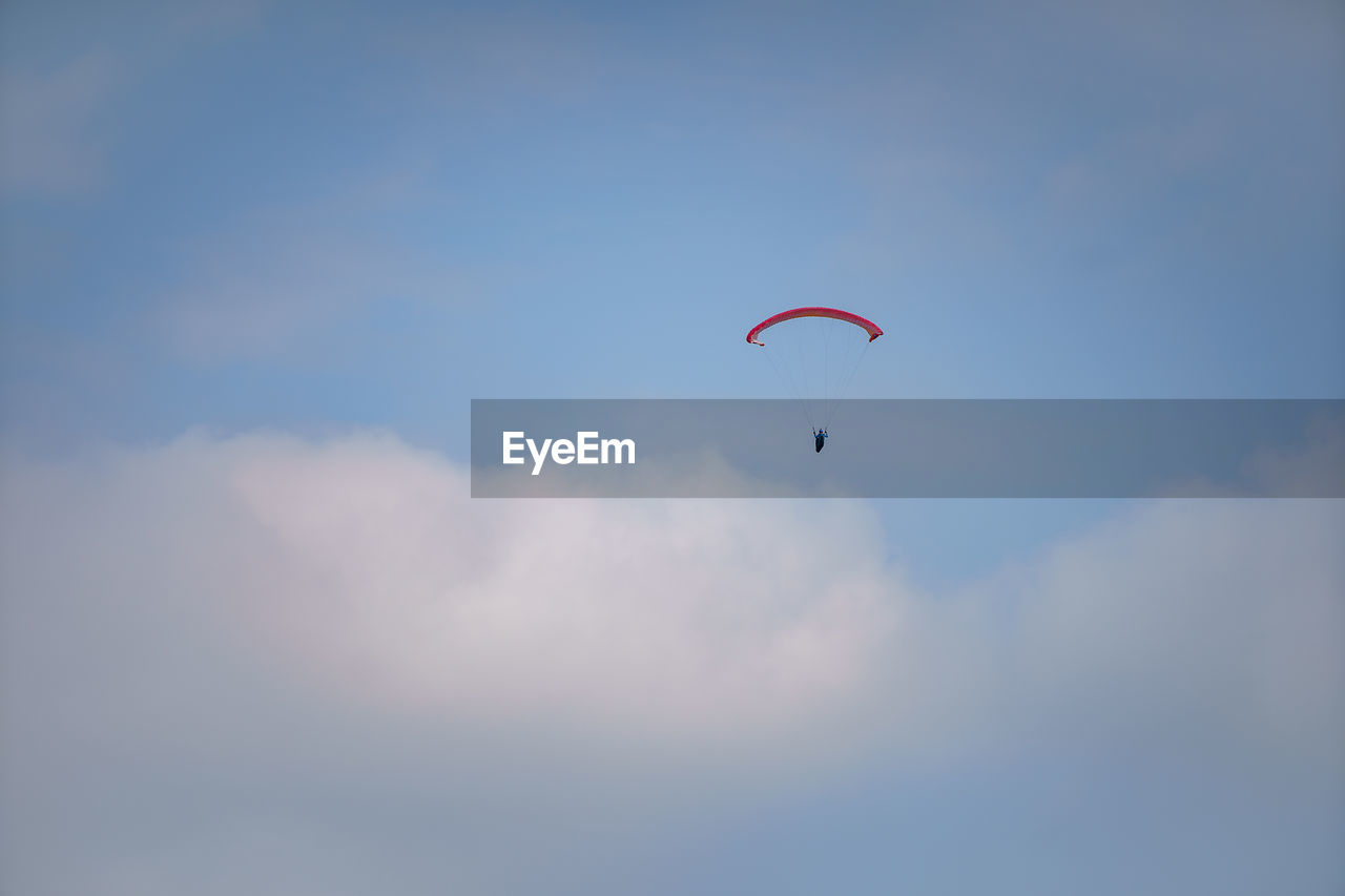 Low angle view of person paragliding against sky