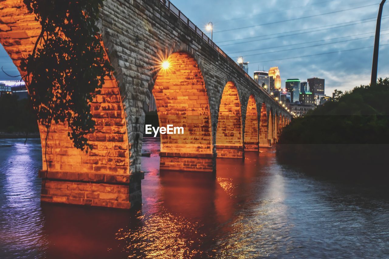 Arch bridge over river against buildings