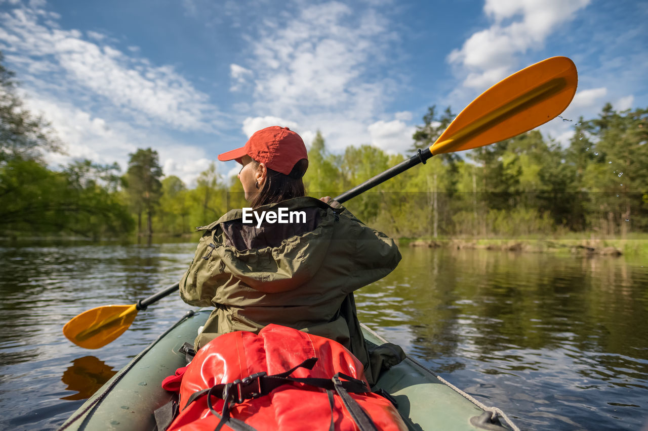 Rear view of woman kayaking in river