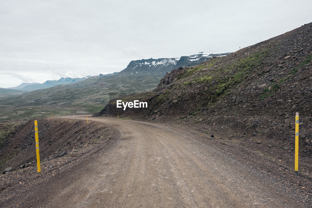 Road by mountain against sky