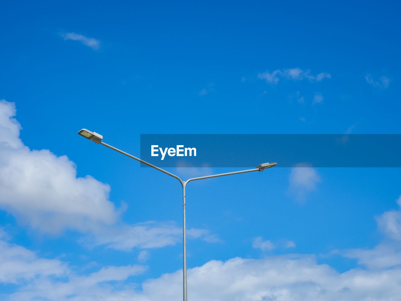 Low angle view of street light against blue sky