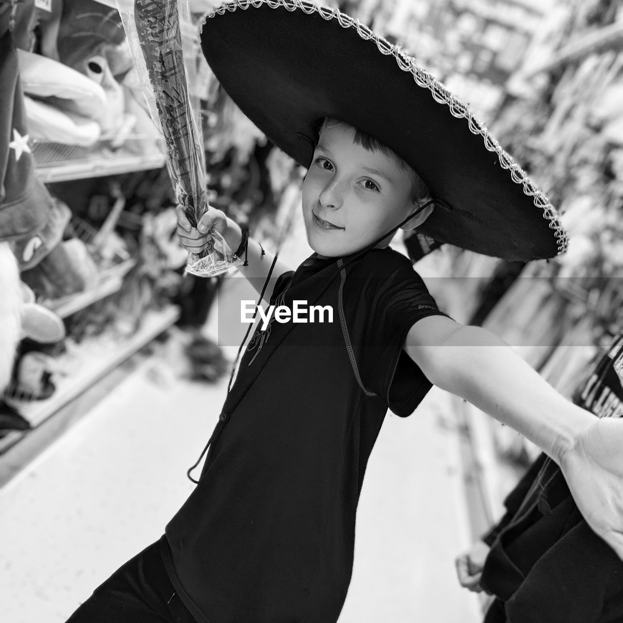 Portrait of boy wearing hat holding toy in store
