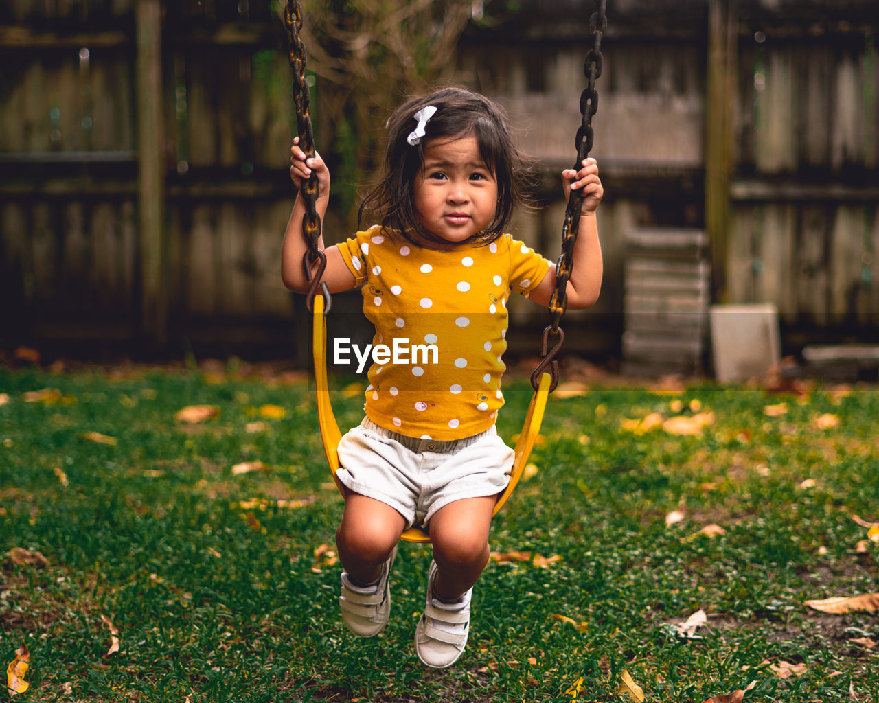 Portrait of cute girl on swing in playground