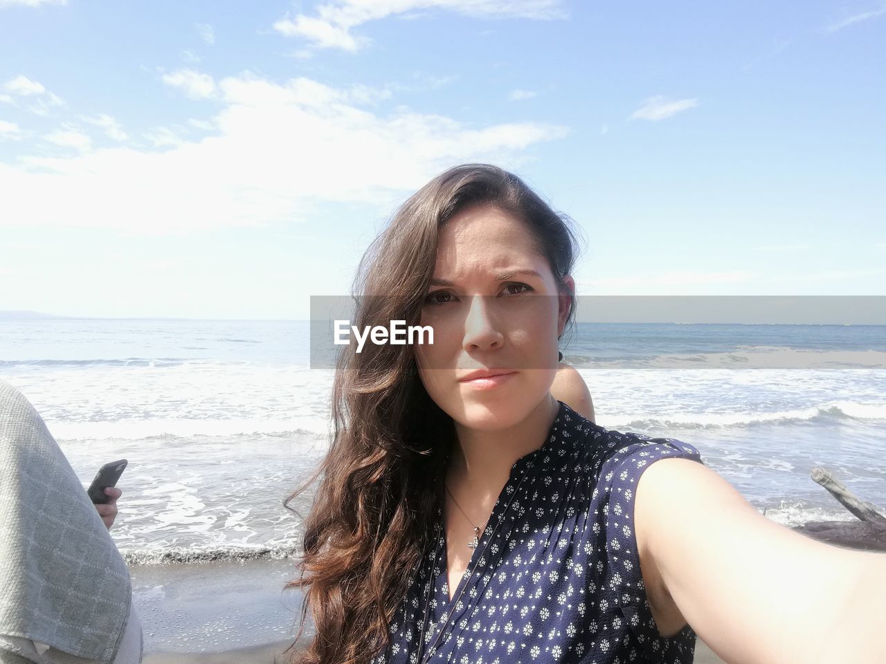 PORTRAIT OF BEAUTIFUL WOMAN STANDING AT BEACH