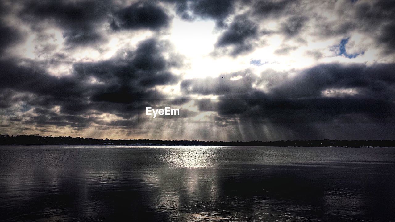 LOW ANGLE VIEW OF LAKE AGAINST STORM CLOUDS