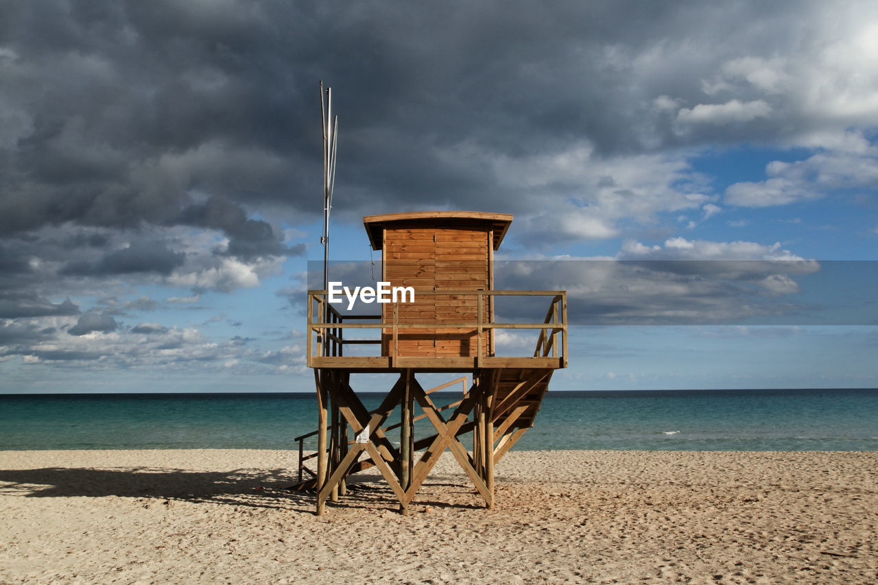 Lifeguard hut on beach against sky