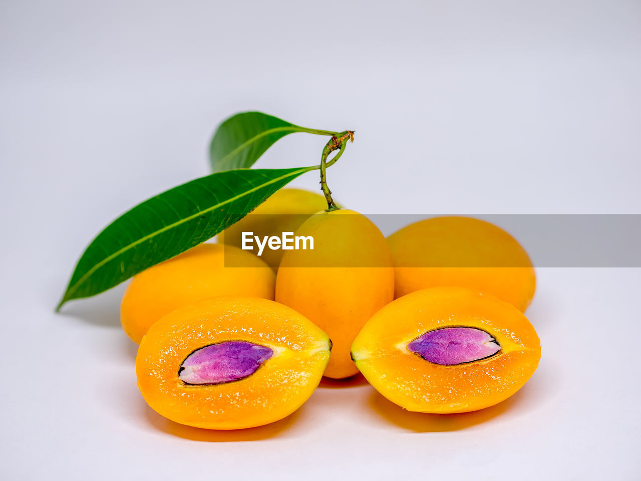 Close-up of marian plums over white background