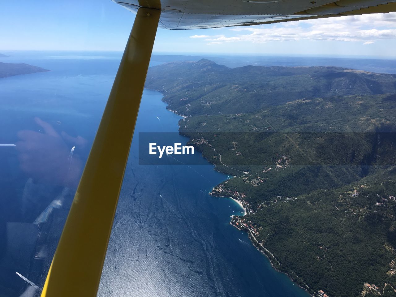AERIAL VIEW OF LANDSCAPE AND SEA AGAINST SKY