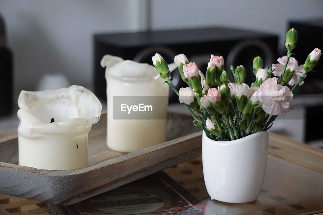 Close-up of white roses in vase on table at home