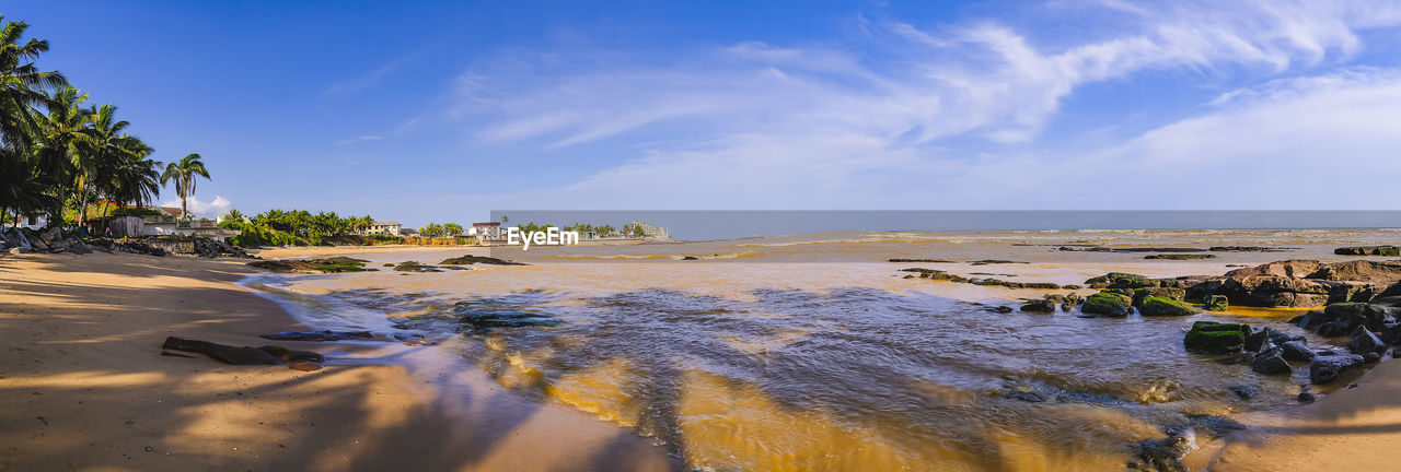 water, land, sky, sea, beach, shore, body of water, coast, nature, sand, environment, ocean, scenics - nature, travel destinations, cloud, beauty in nature, travel, tropical climate, landscape, tree, palm tree, tourism, plant, blue, vacation, trip, coastline, holiday, tranquility, wave, horizon, outdoors, bay, sunlight, no people, summer, tranquil scene, day, island, seascape, reflection, coconut palm tree, water's edge, sunny, natural environment, sunset, idyllic, panoramic