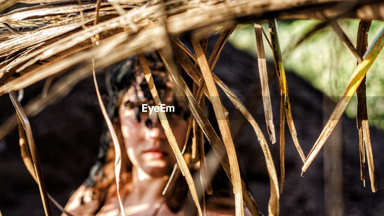 Portrait of woman seen through thatched roof