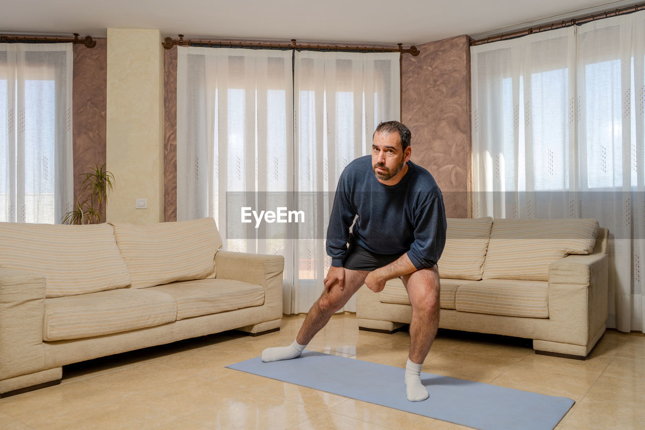 FULL LENGTH PORTRAIT OF MAN AT HOME