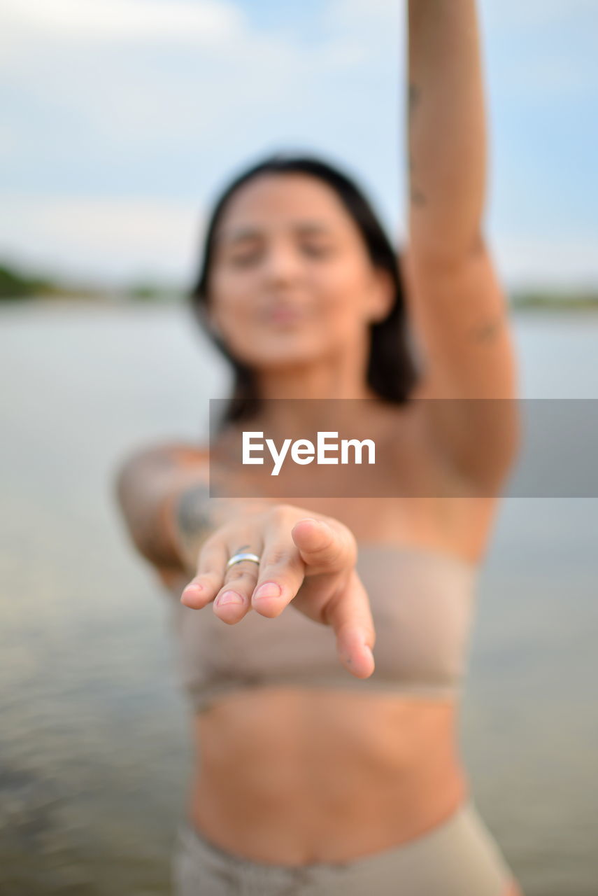 Young woman exercising by lake