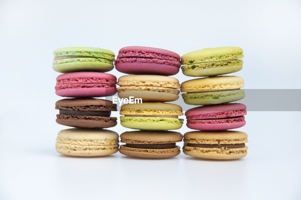 Stack of multi colored macaroons against white background