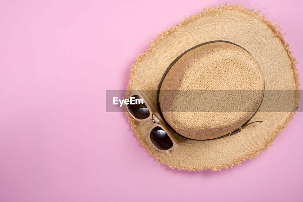 HIGH ANGLE VIEW OF HAT ON PINK OVER WHITE BACKGROUND