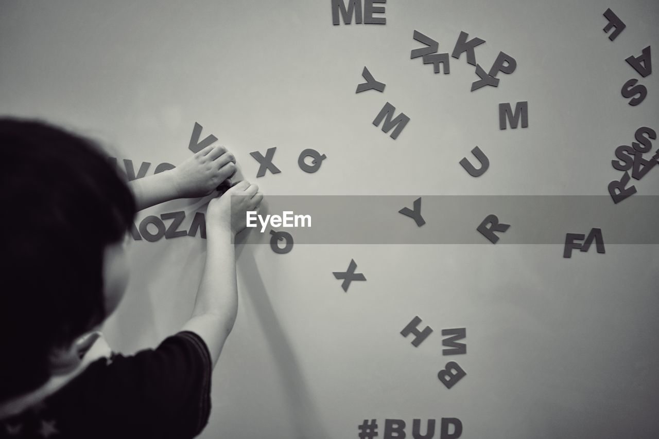 Girl playing with alphabets against wall