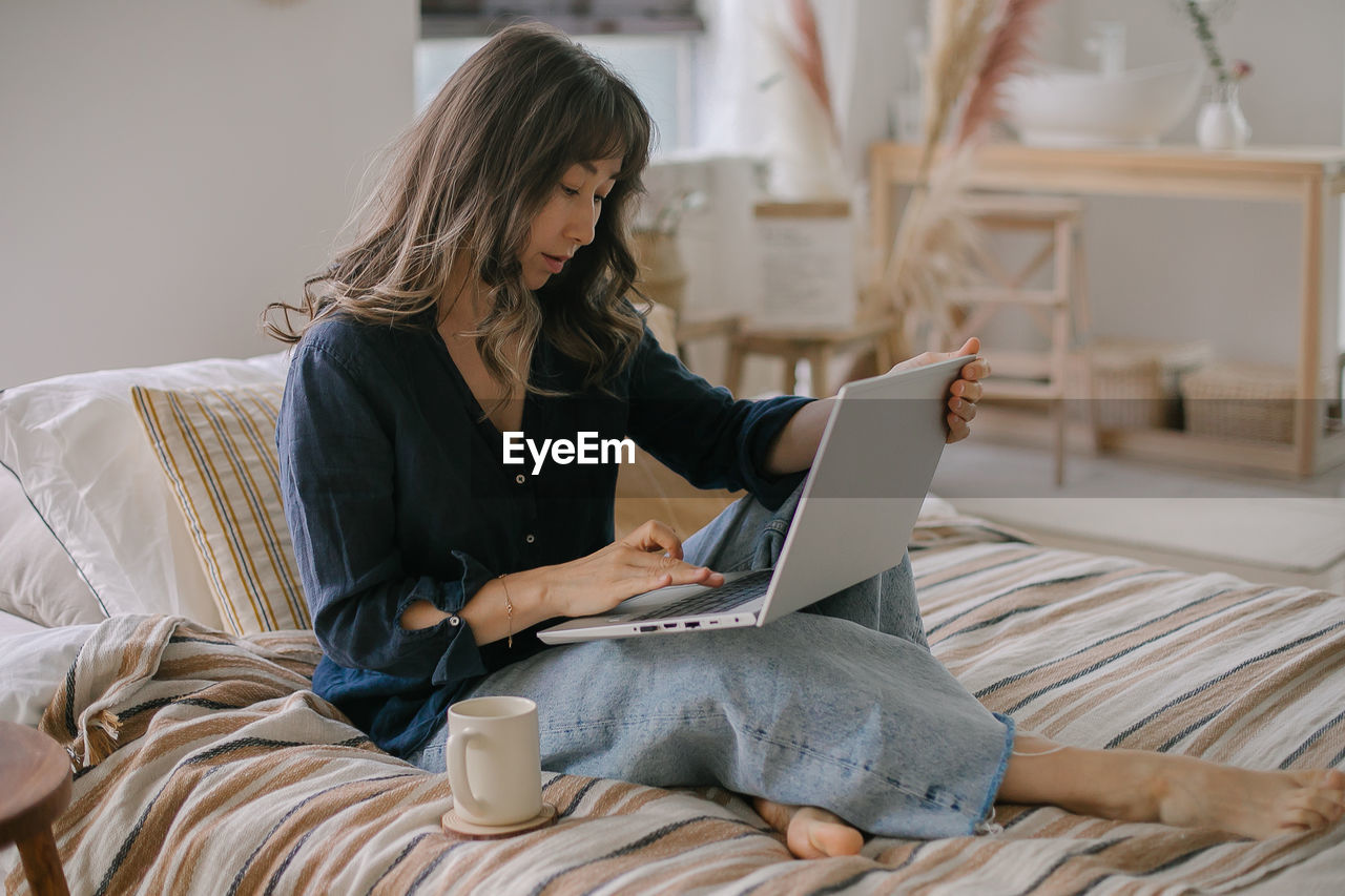 Young woman using laptop at home