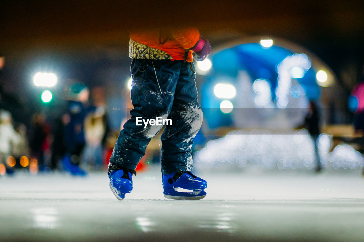 Low section of man ice-skating at night