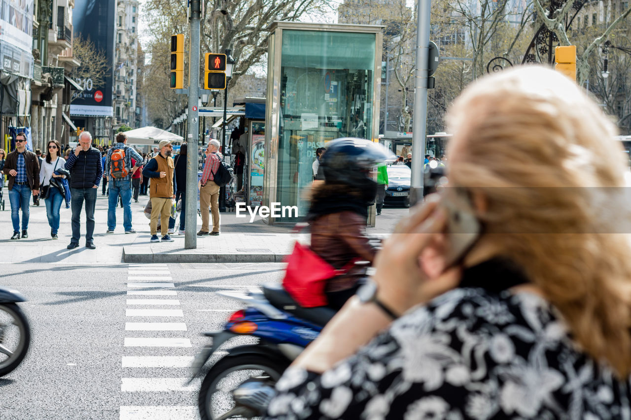 MAN PHOTOGRAPHING WOMAN WITH ARMS OUTSTRETCHED