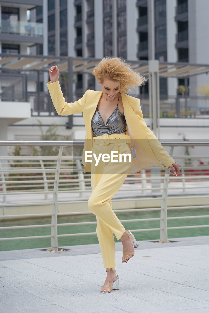 Urban style street fashion photosoot young model wearing yellow trendy suit