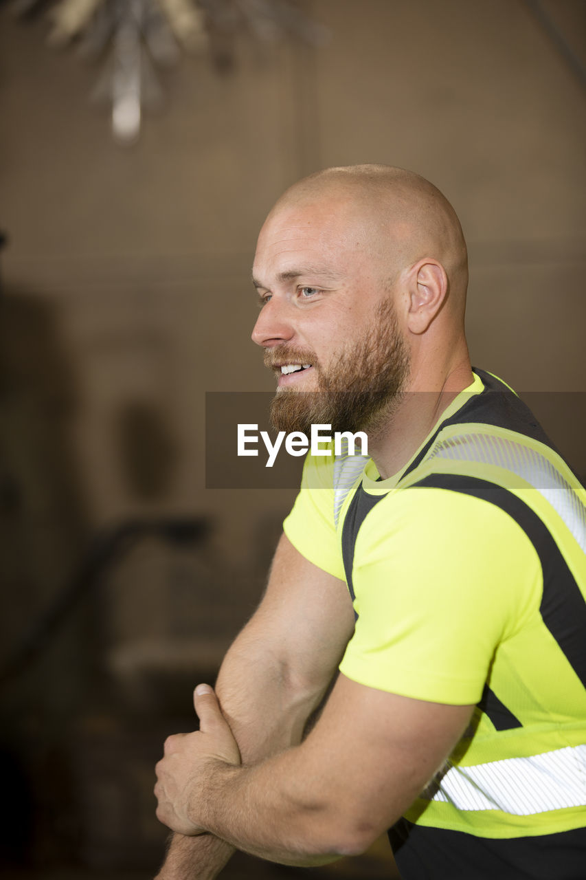 Smiling male worker in reflective clothing