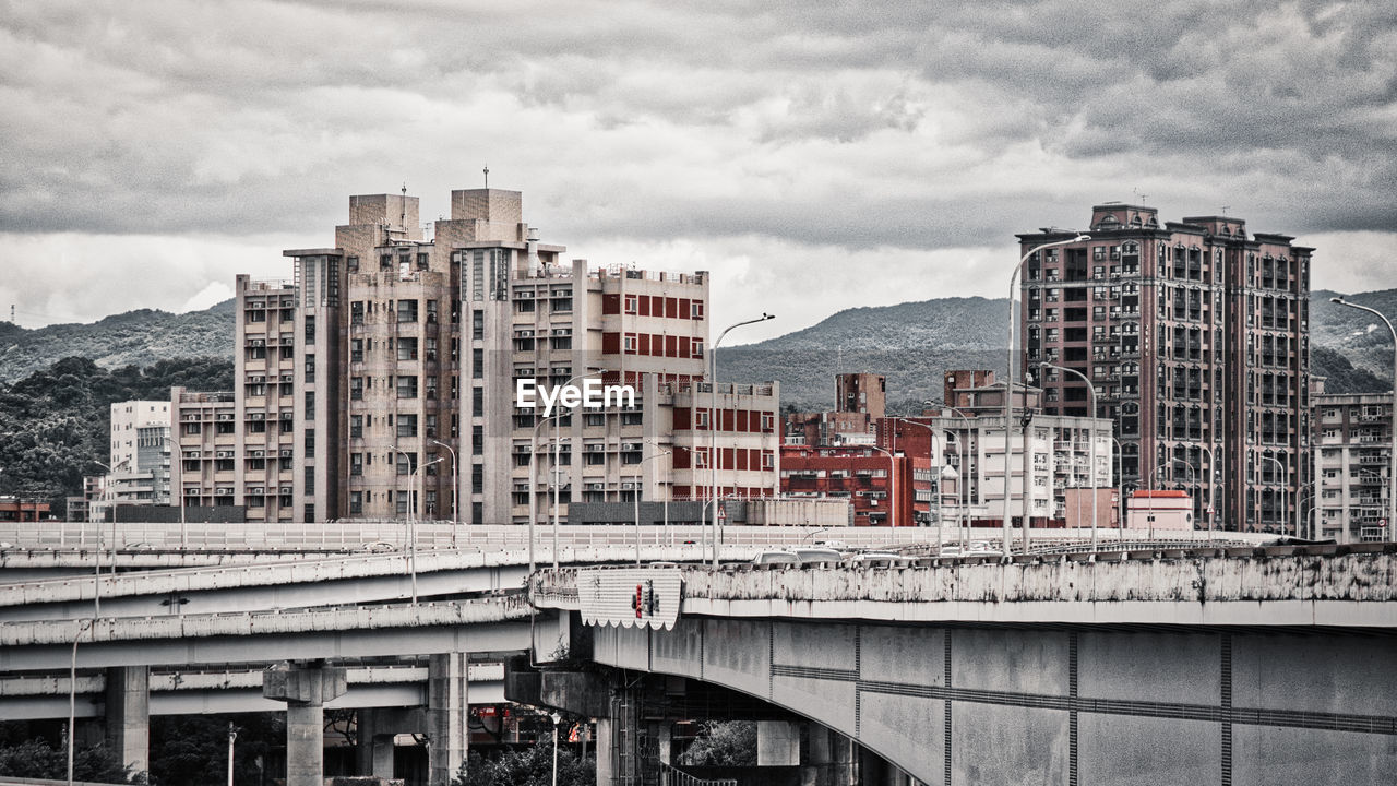 Bridge over buildings in city against sky